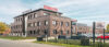Modernes Schulte Firmengebäude aus Klinker mit rotem Logo und Parkplatz vor dem Hauptsitz des Bauunternehmens